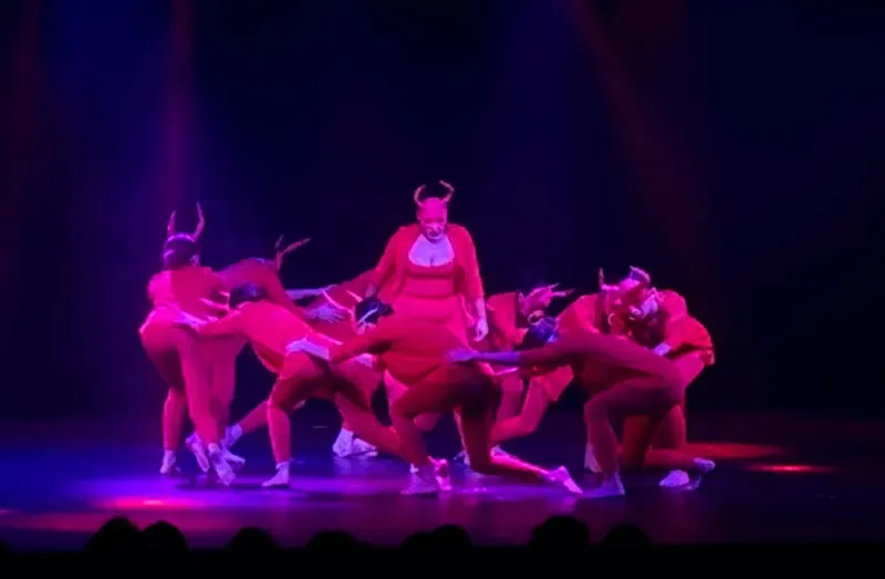 Una coreografia sotto le luci rosse e viola