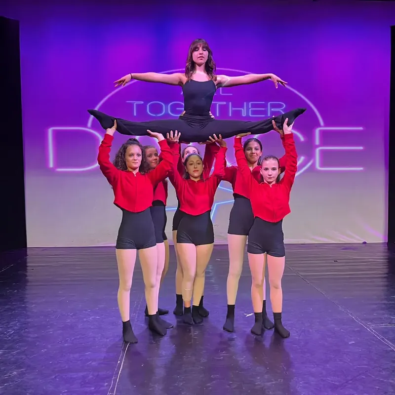 Una ballerina sollevata in spaccata dal suo gruppo