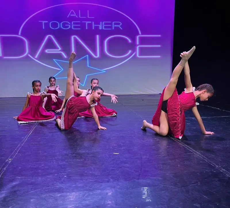 Ballerine in abito rosso a terra, durante una coreografia