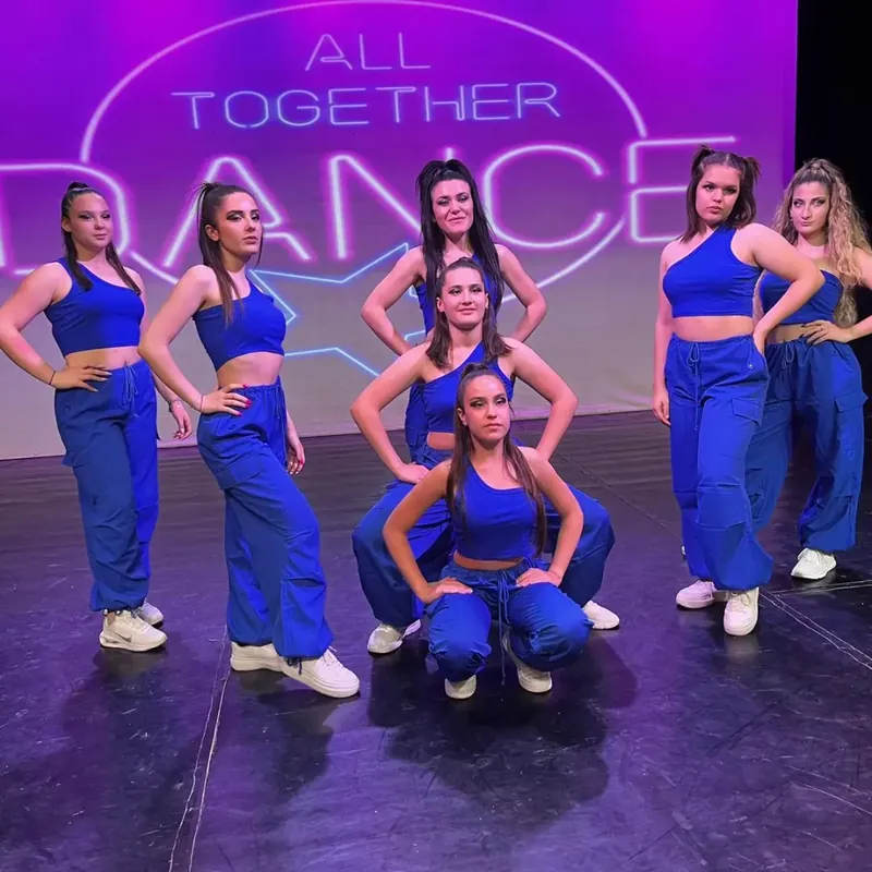 Ballerine in blu in posa sul palco di All Together Dance