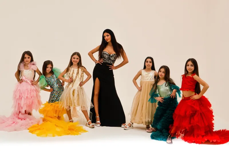 Bambine e ragazze in abiti da sera colorati, in posa in studio
